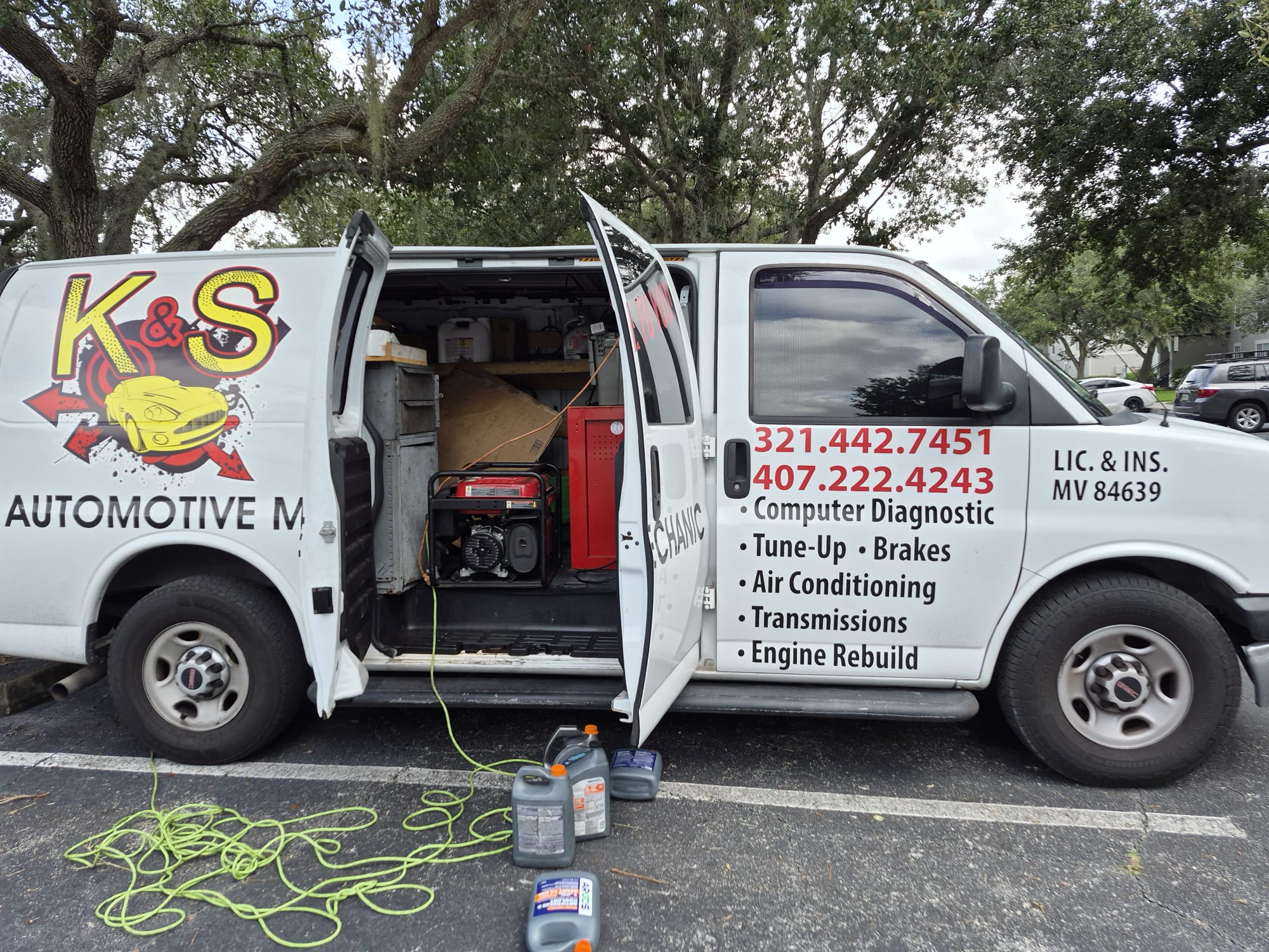 The K&S service van with rear doors open, stocked with tools and a generator