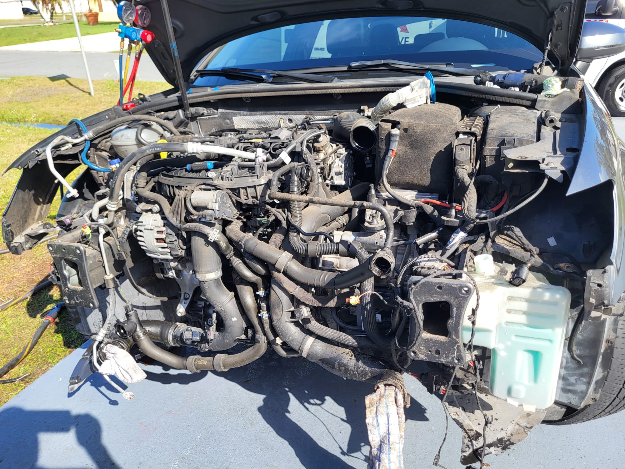 Close-up of an engine bay with AC manifold gauges connected